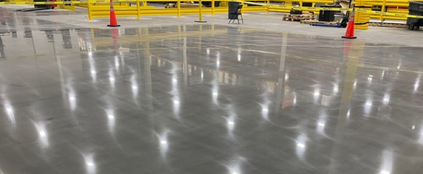 Conditioned concrete slab surface prepared for consistent robotic traffic and automation performance in a high traffic distribution center.