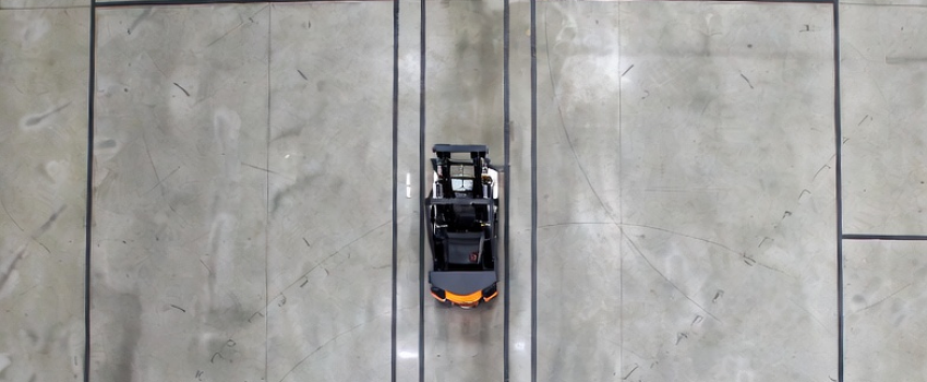 Concrete floor condition affecting AMR wheel traction, acceleration response, and braking control.