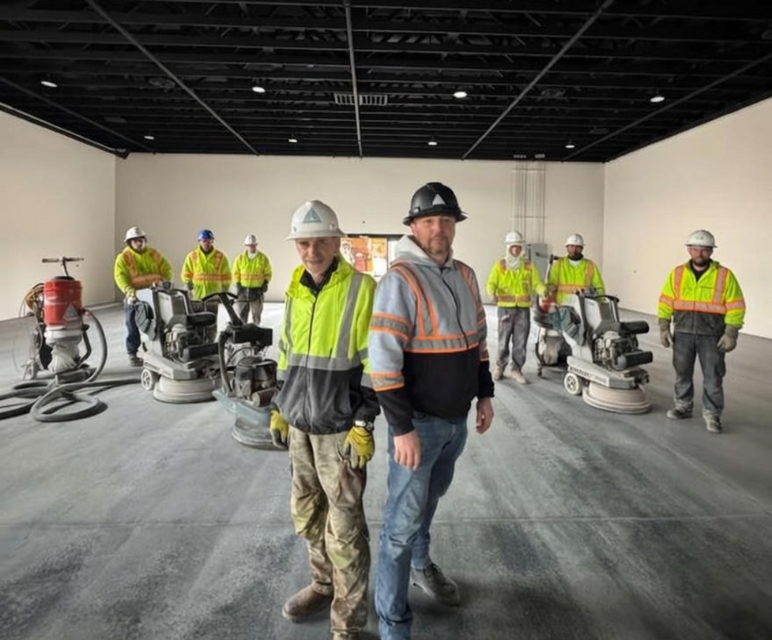 Concrete floor correction crew performing precision grinding and verification inside an industrial facility to restore flatness and operational performance.